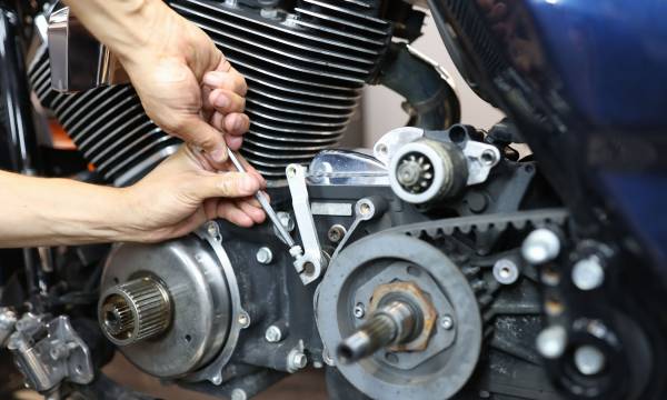 Master repairman repairing motorcycle in workshop closeup. Repair and maintenance of motorcycles concept