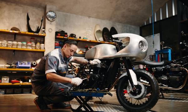 Repairman choosing tool when fixing motorcycle in his repairshop