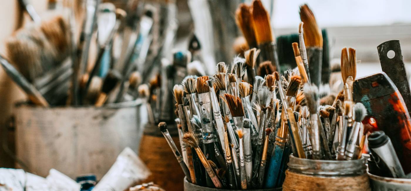 Table with brushes and tools in an art workshop. Background.